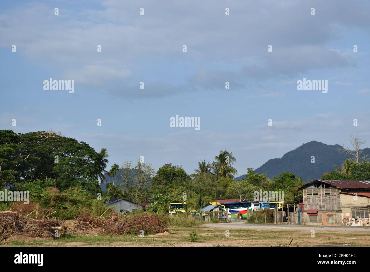 Vue sur la rue avec maisons et un bus depo à Langkawi en Malaisie. Banque D'Images