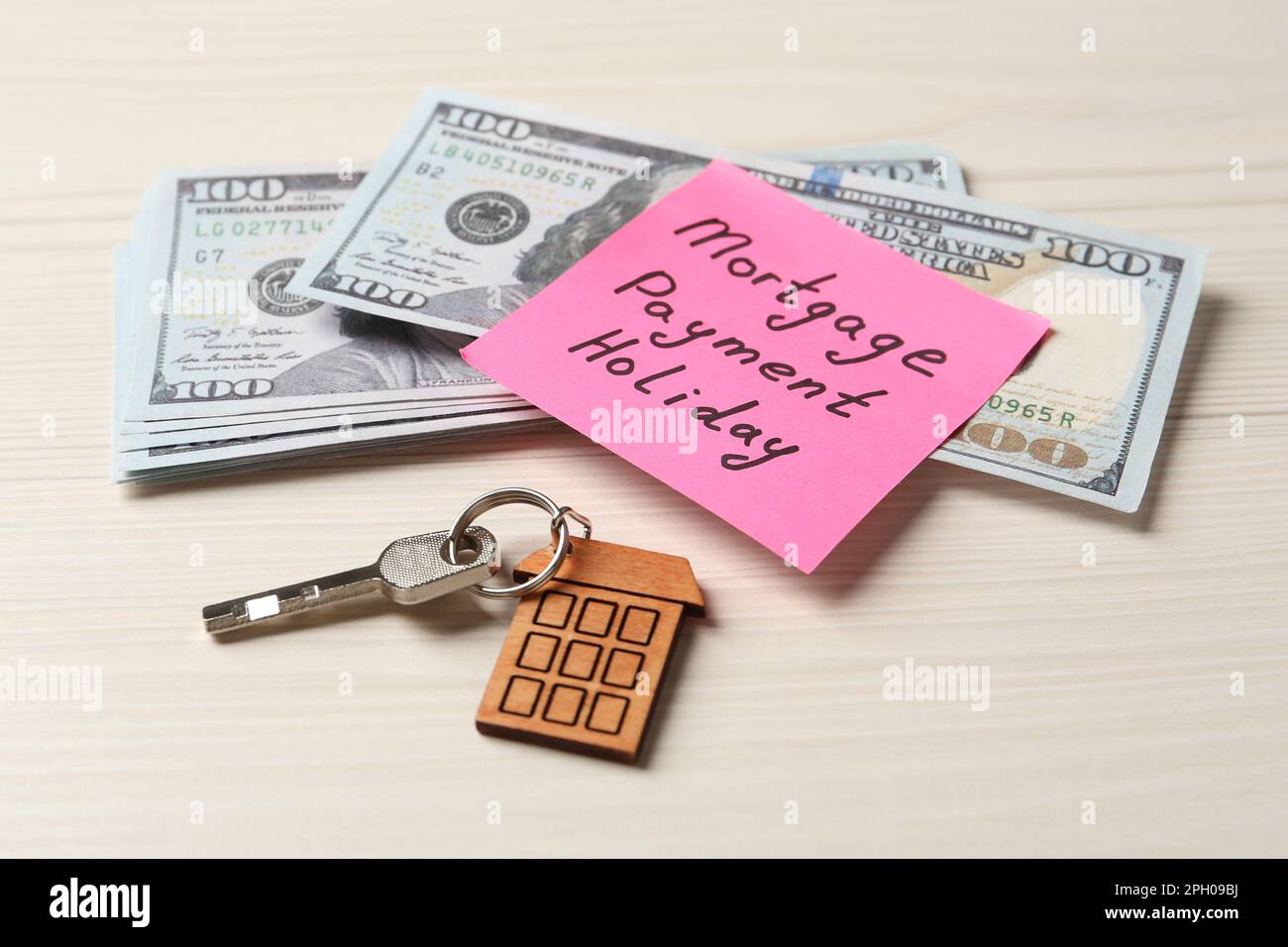 Note papier avec des mots paiement hypothécaire vacances, clé et argent sur table blanche en bois Banque D'Images