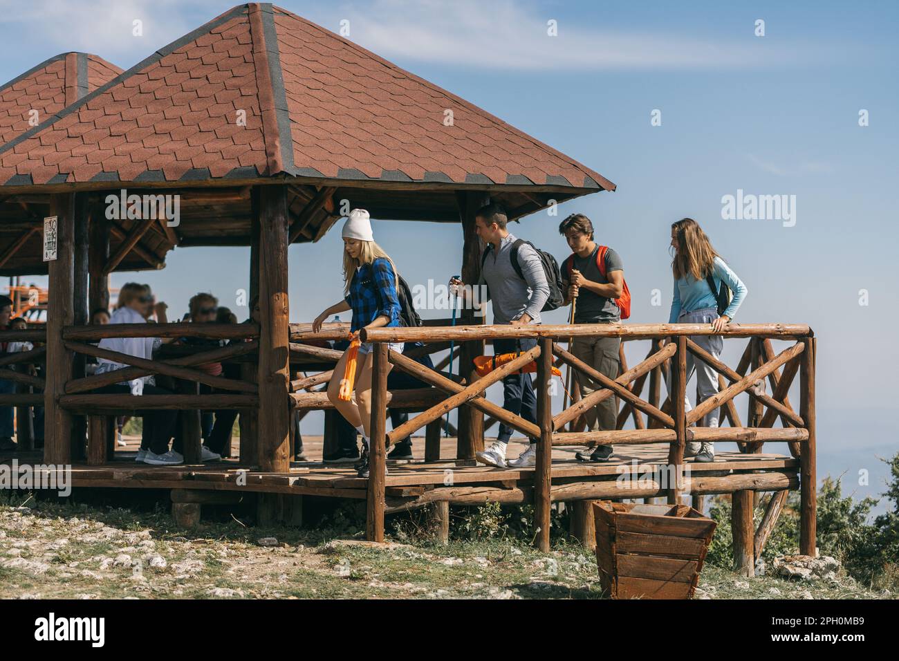 Quatre randonneurs marchent loin du banc en bois Banque D'Images