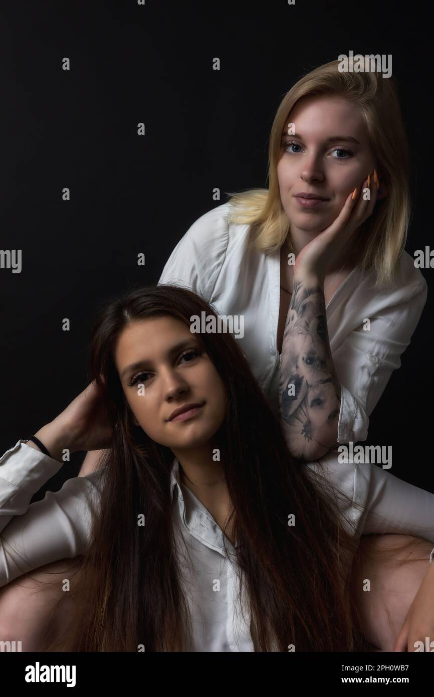 Portrait de deux belles jeunes femmes assis dans le studio. Verticalement. Banque D'Images