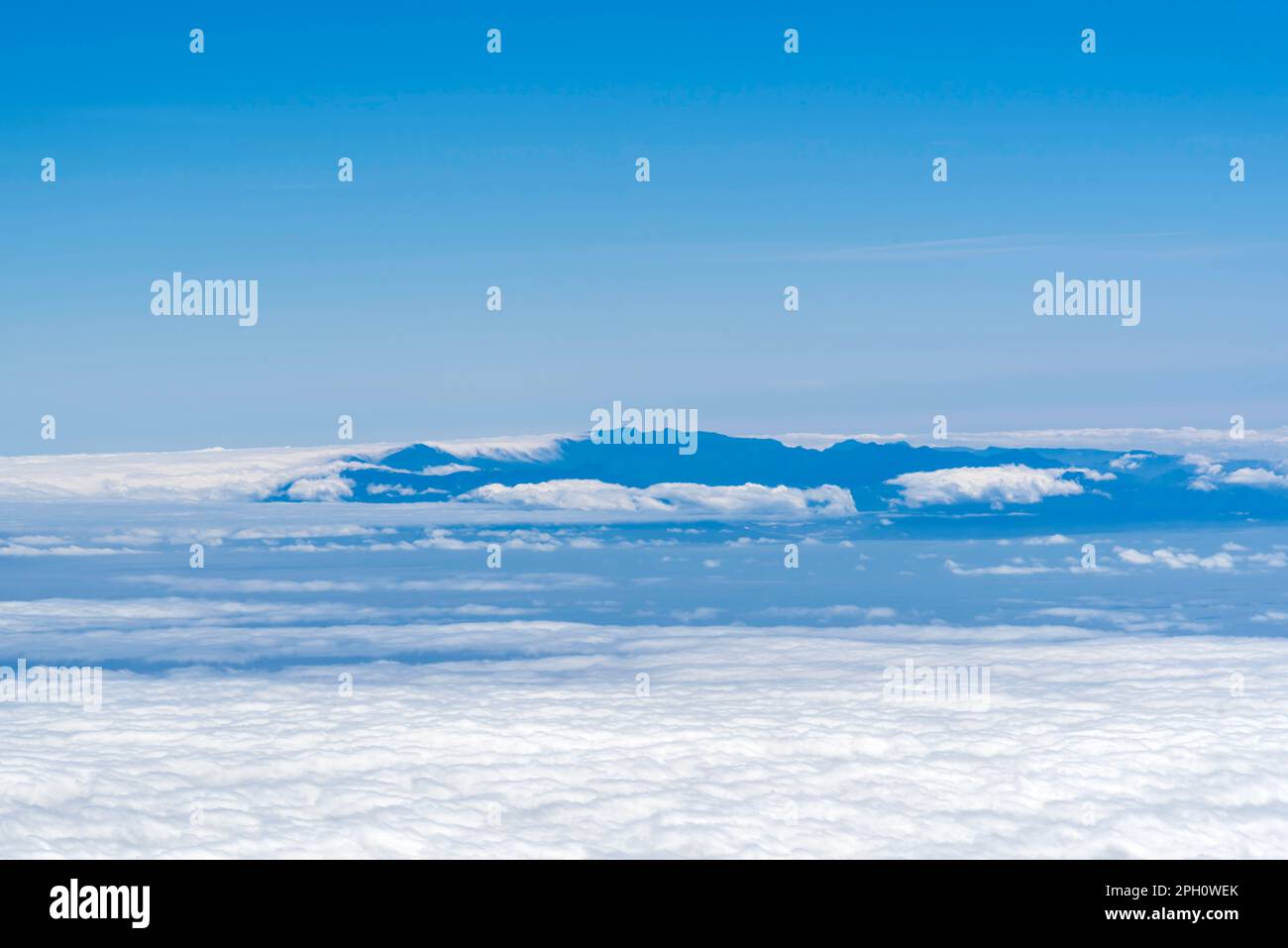 Vue d'en haut des nuages sur les montagnes loin Banque D'Images