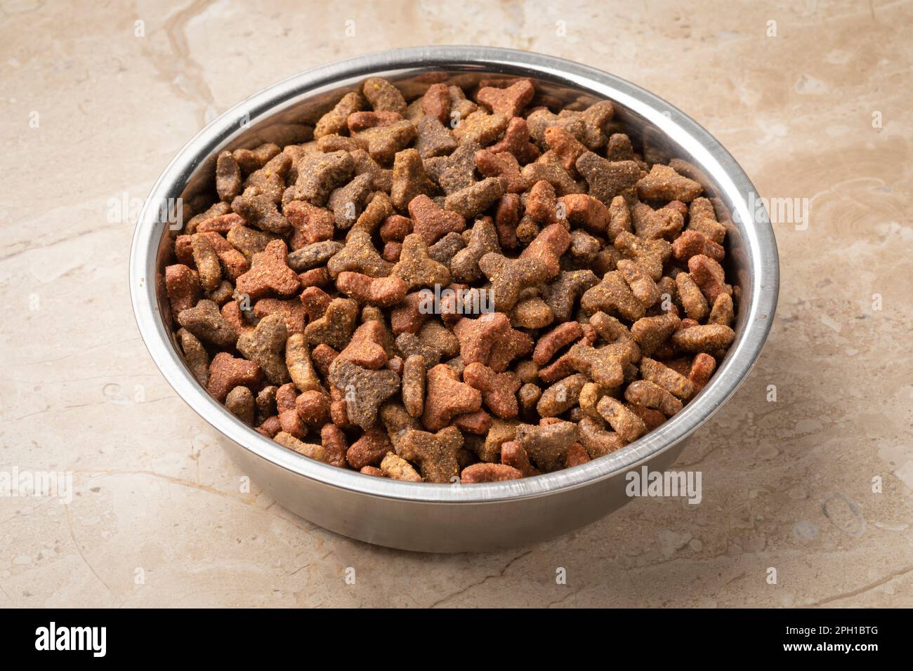 Bol en métal avec nourriture sèche pour chats pour un repas en gros plan Banque D'Images