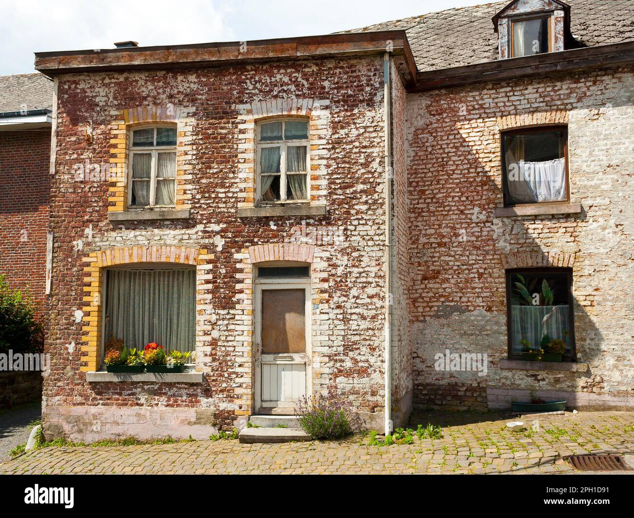 Une maison de trois étages en briques brunes contre un ciel bleu vif Banque D'Images