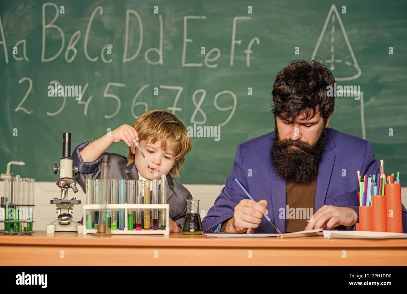 Étudier est intéressant. Exemple personnel et inspiration. Étudier l'activité éducative par l'expérience. J'aime étudier à l'école. Professeur et garçon Banque D'Images