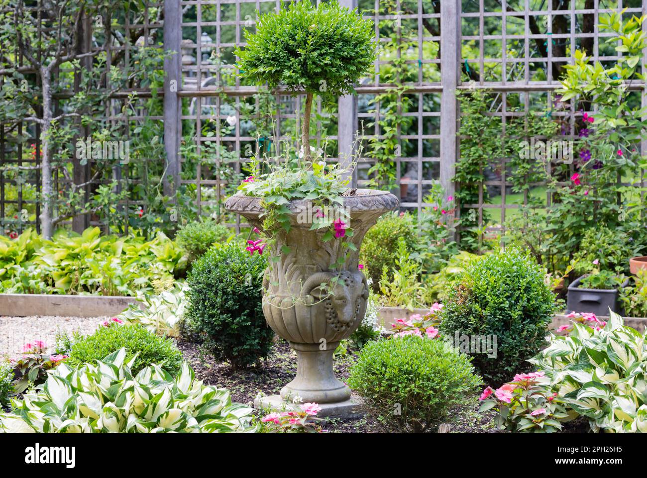 Joli jardin mettant en valeur un jardinier en pierre très orné. Banque D'Images