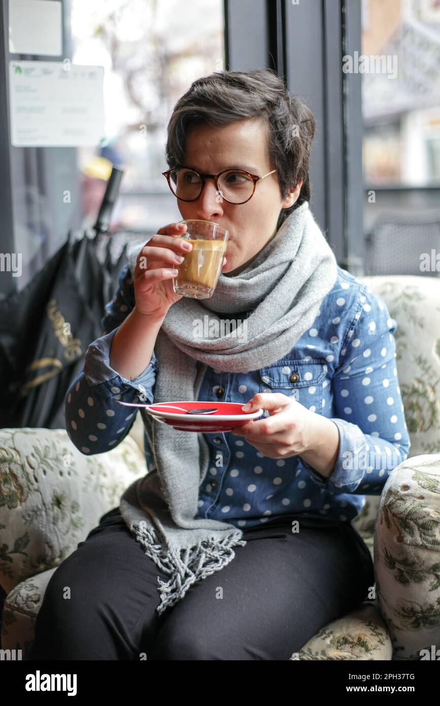 Une fille qui boit du café dans un café Banque D'Images