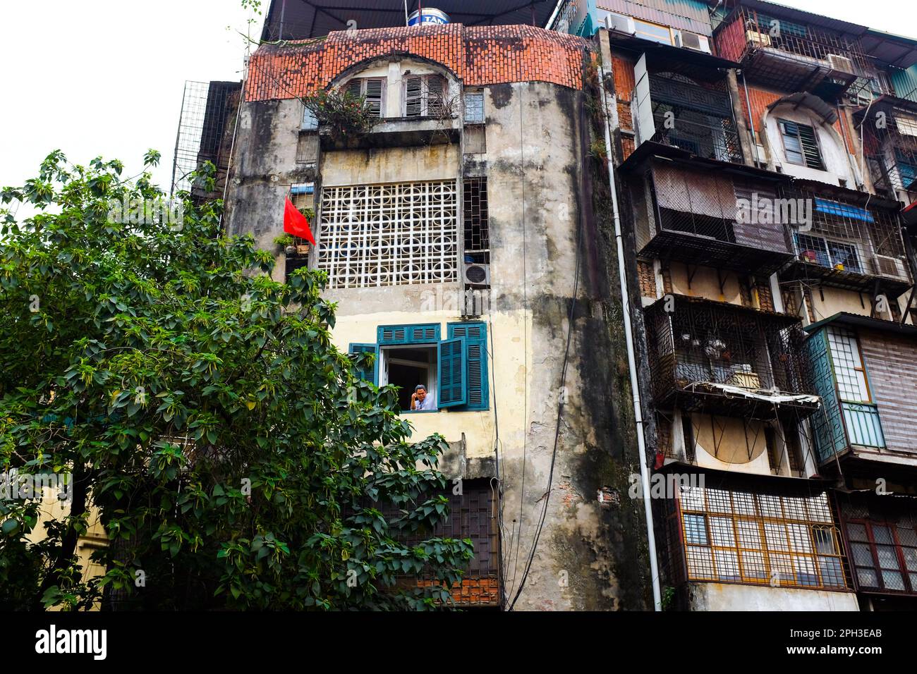 Un homme regarde par une fenêtre à Hanoi, Vietnam, en 2023. Banque D'Images