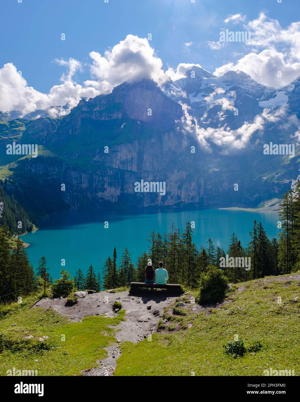 Couple d'hommes et de femmes visitant le lac Oeschinensee. Une magnifique scène en plein air dans les Alpes suisses avec la montagne Bluemlisalp, emplacement du village de Kandersteg, Suisse, Europe. Banque D'Images