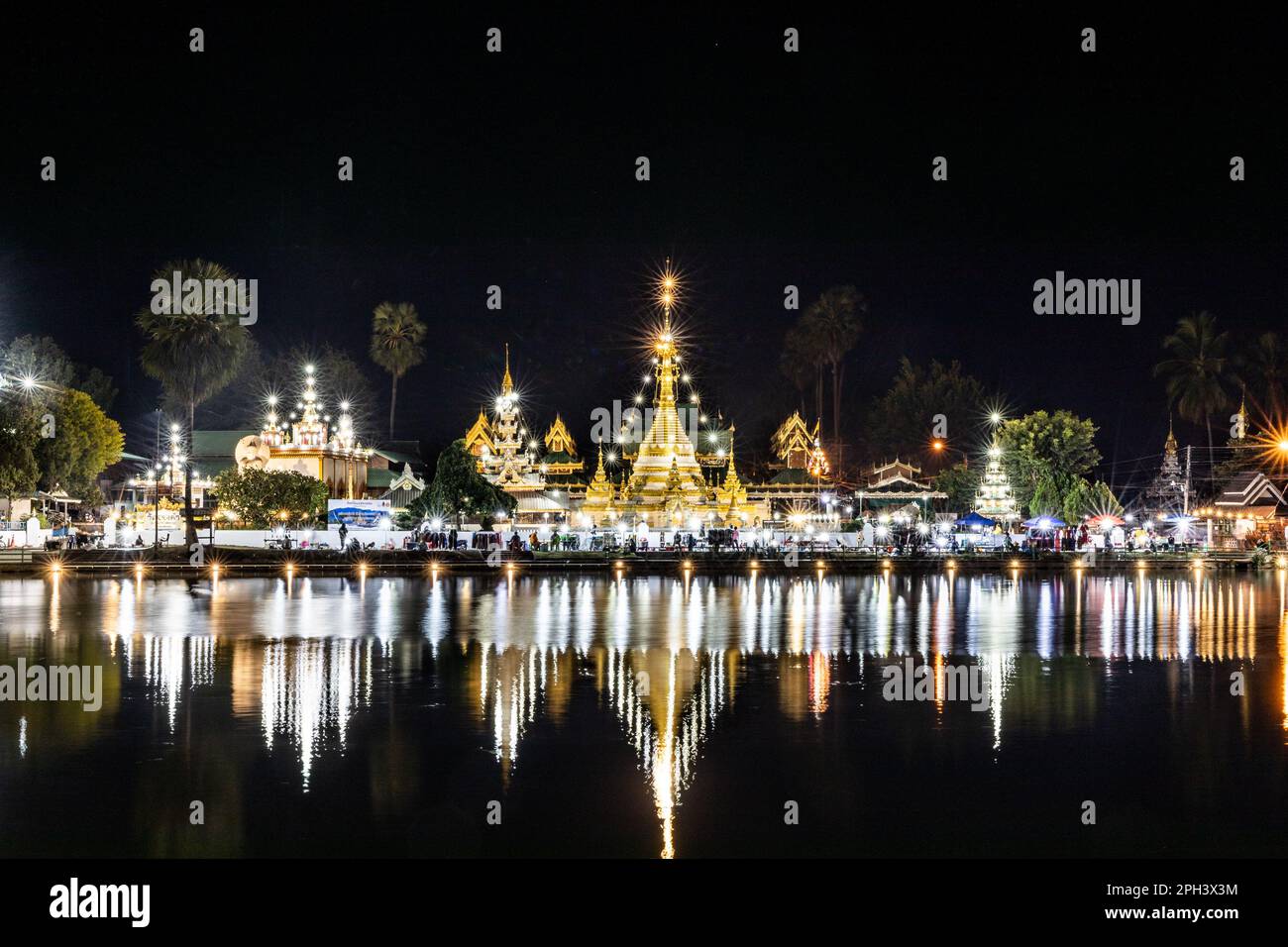 Bien éclairé Wat Chong Kham à Mae Hong son Thaïlande la nuit, avec réflexion du lac Banque D'Images