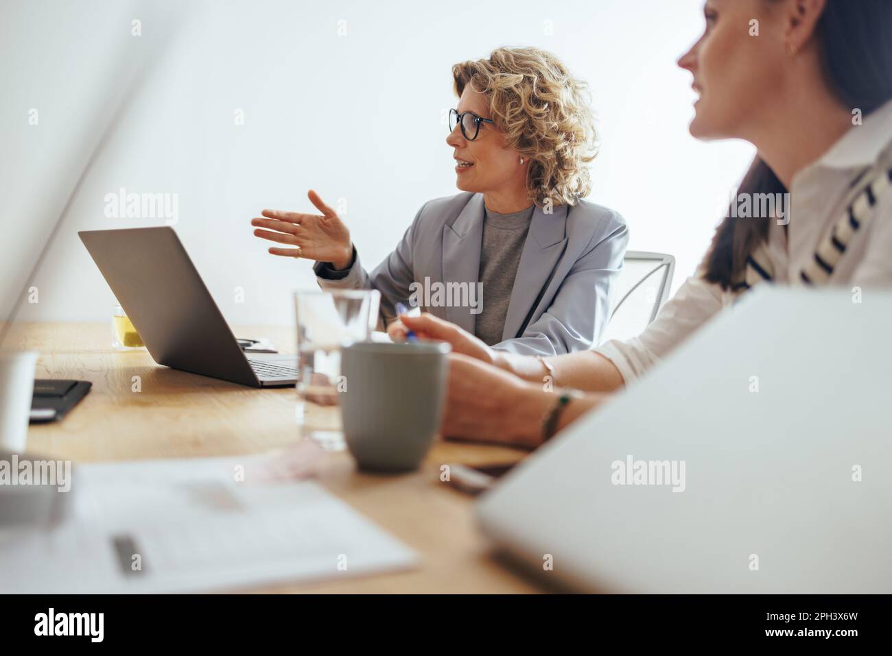 Femme d'affaires mature discutant d'un projet avec son équipe dans un bureau. Des gens d'affaires créatifs ayant une réunion dans une salle de réunion. équipe commerciale travaillant Banque D'Images