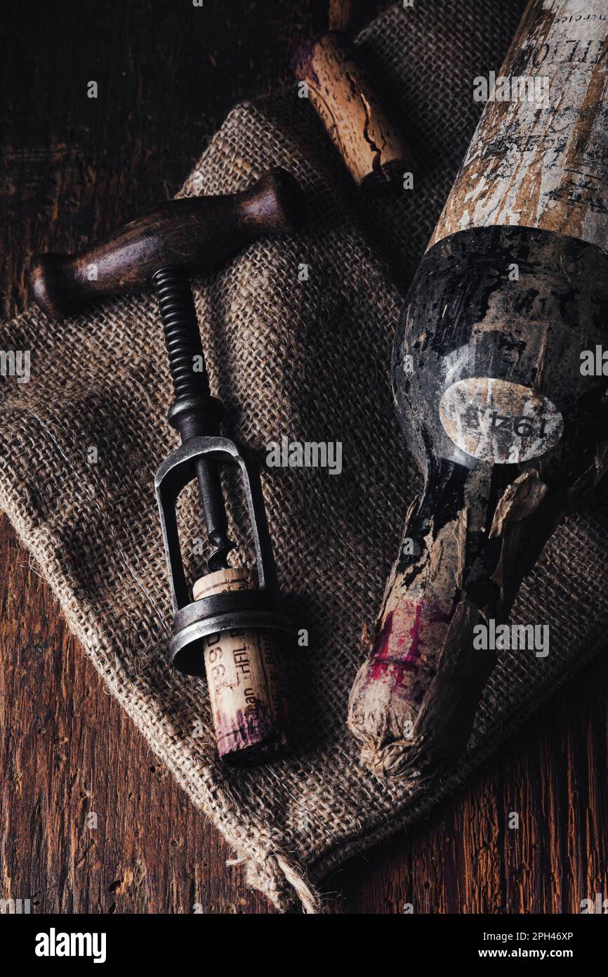 ancienne bouteille de vin rouge avec tire-bouchon sur fond de bois Banque D'Images