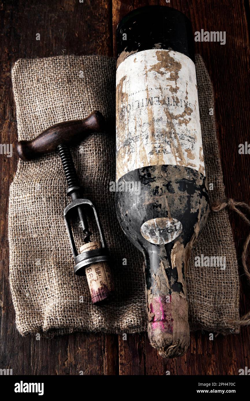 ancienne bouteille de vin rouge avec tire-bouchon sur fond de bois Banque D'Images