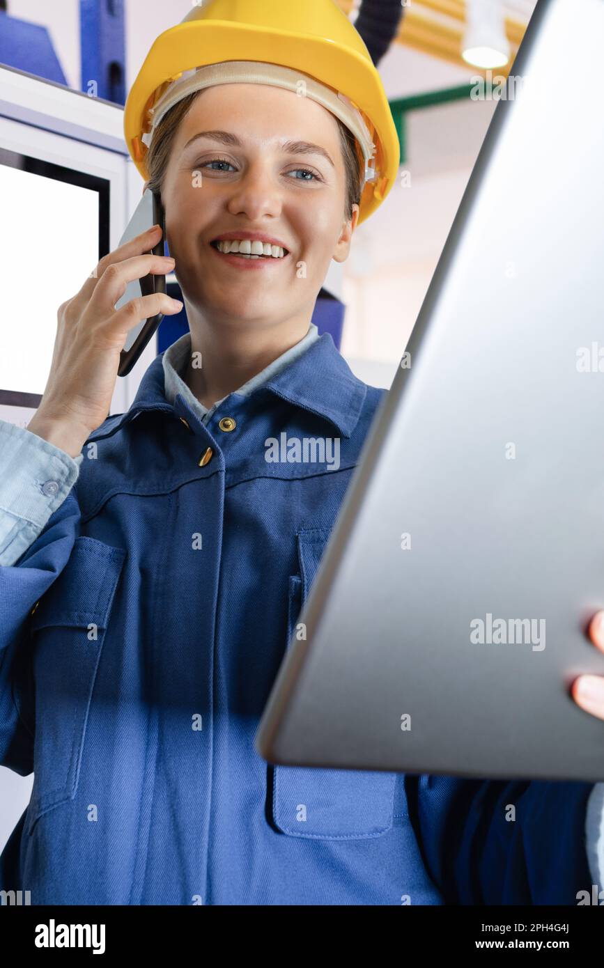 Femme ingénieur avec une tablette numérique et un téléphone dans une usine intelligente. Gros plan. Photo de haute qualité Banque D'Images