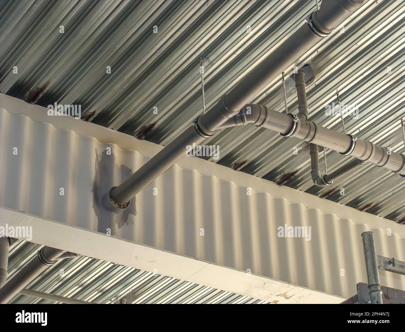 Un cadre en métal fait d'une poutre SIN et d'un tuyau découpé dans celle-ci. Construction de poutres en I ondulées. Banque D'Images