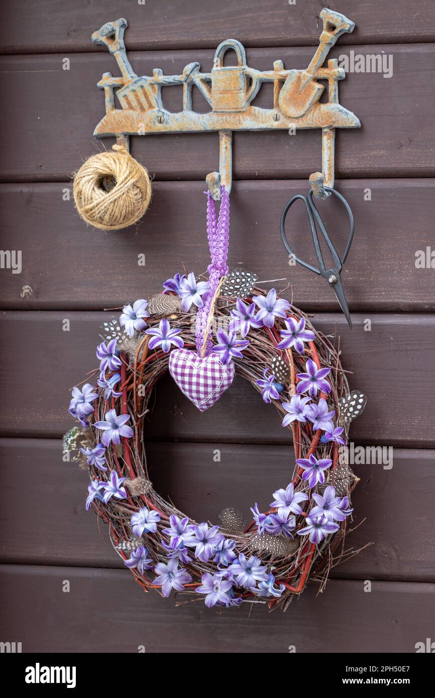 couronne avec fleurs en jacinthe violettes accrochées sur la bande de crochet de jardin Banque D'Images