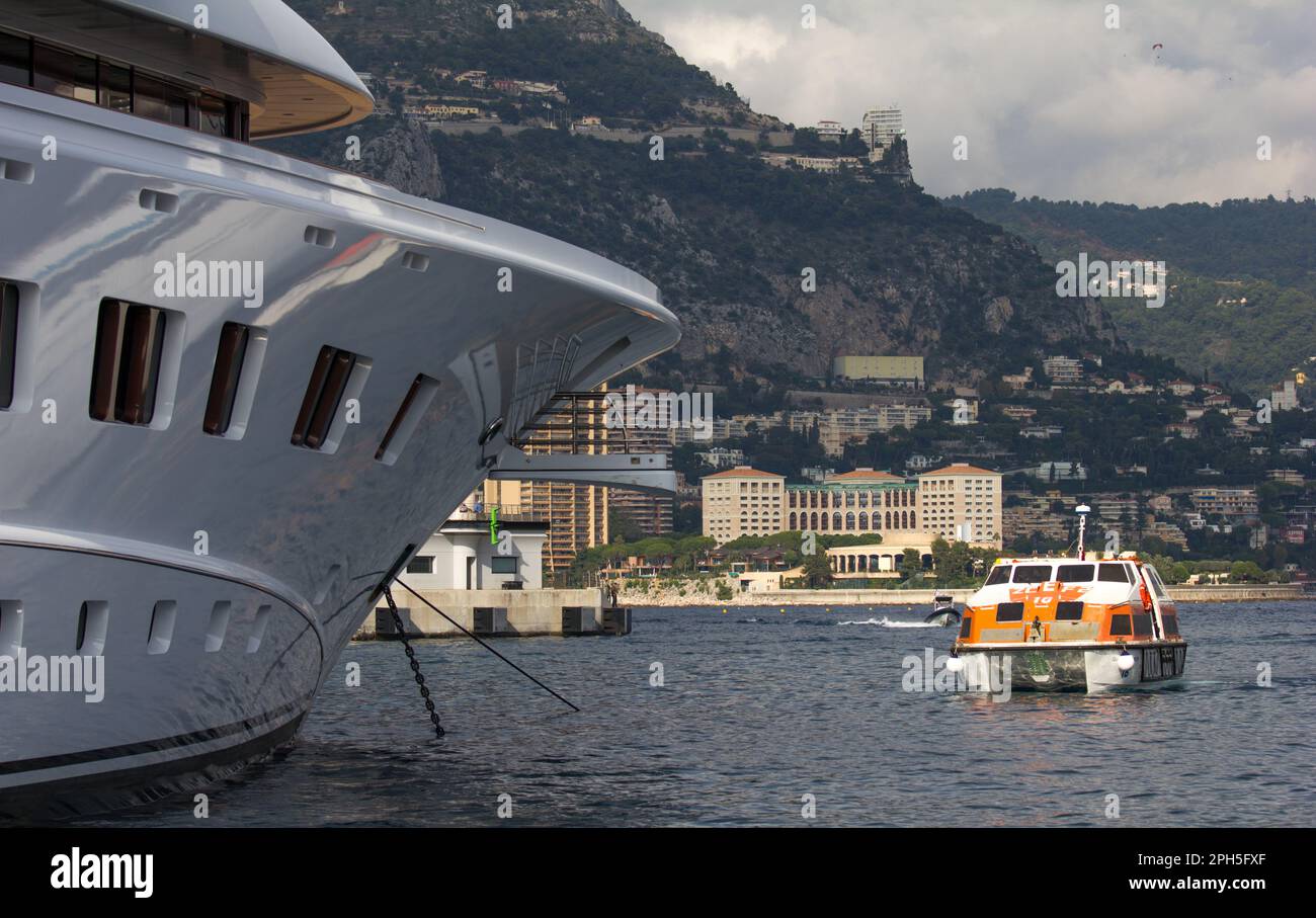 Contraste entre le paquebot de croisière Cunard Queen Elizabeth's Tender et un super yacht de luxe dans le Port Hercule, Monte Carlo, Monaco. Banque D'Images