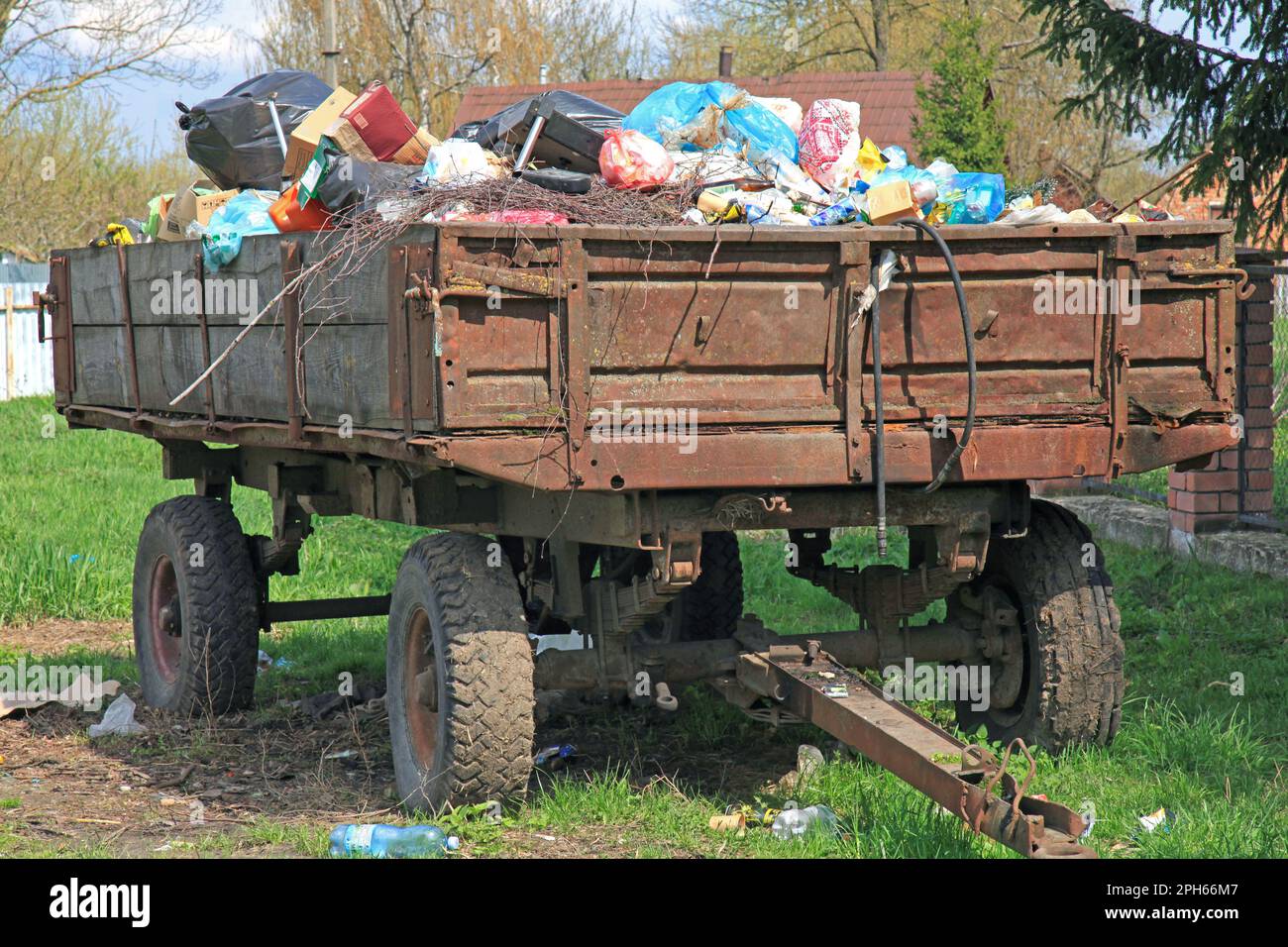 Corbeille non recyclée. Les déchets sont en vrac sur une remorque de chargement à partir d'un tracteur. Pollution de l'environnement. Déchets recyclables ou ménagers. Écologie Banque D'Images