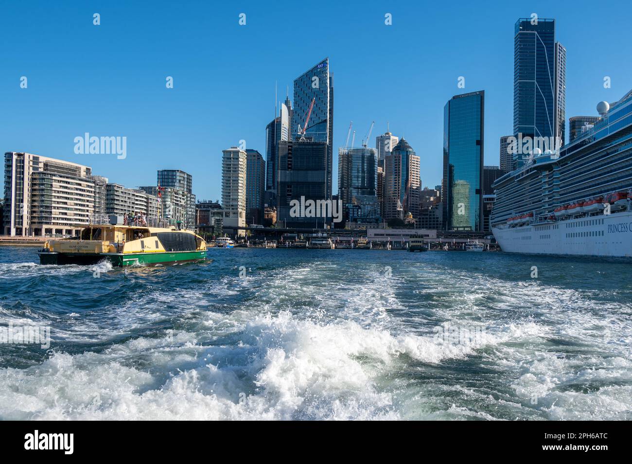 Circular Quay et le Central Business District, CBD Beyond, Sydney, Nouvelle-Galles du Sud, Australie. Un traversier entre dans le port et un paquebot de croisière i Banque D'Images