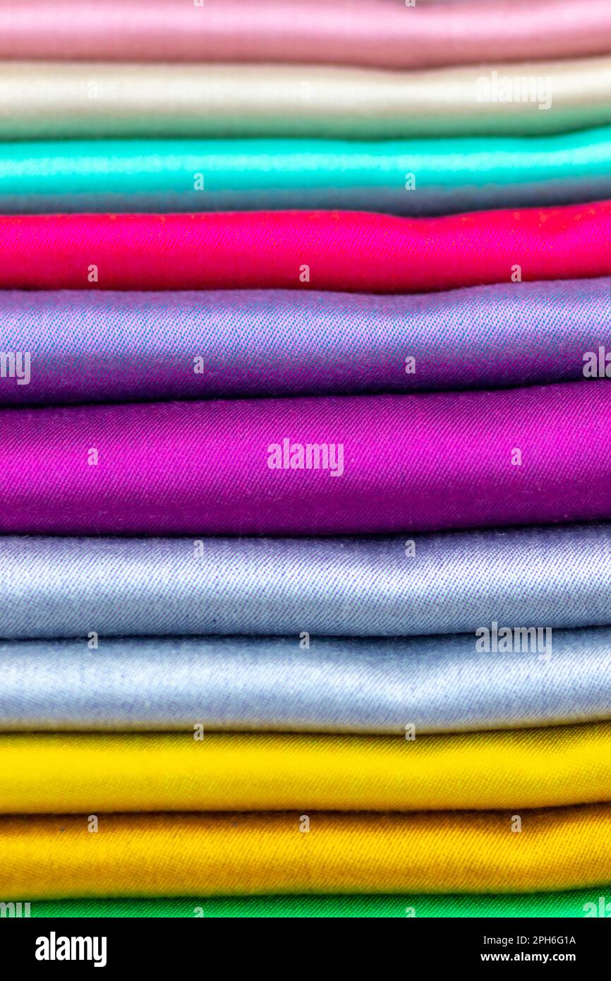Tissu en soie aux couleurs arc-en-ciel brillant à la lumière du soleil dans un magasin exposé Banque D'Images