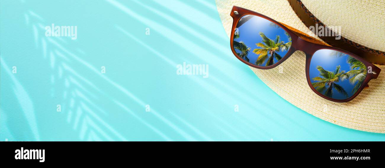 concept de vacances et de voyage d'été bannière. Joyeuses vacances sur la plage de sable tropical. Chapeau de Panama et lunettes de soleil avec un reflet du trovic de sable Banque D'Images