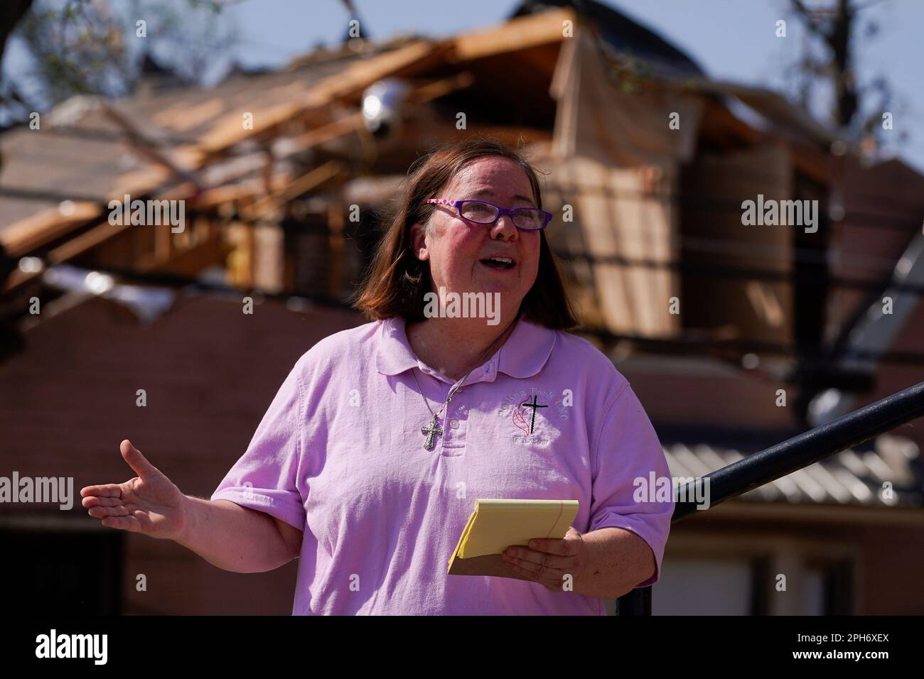 Rev. Mary Stewart, of Rolling Fork United Methodist Church, leads a prayer as people worship on the steps of the church, Sunday, March 26, 2023, in Rolling Fork, Miss. Emergency officials in Mississippi say several people have been killed by tornadoes that tore through the state on Friday night, destroying buildings and knocking out power as severe weather produced hail the size of golf balls moved through several southern states. (AP Photo/Julio Cortez) Banque D'Images