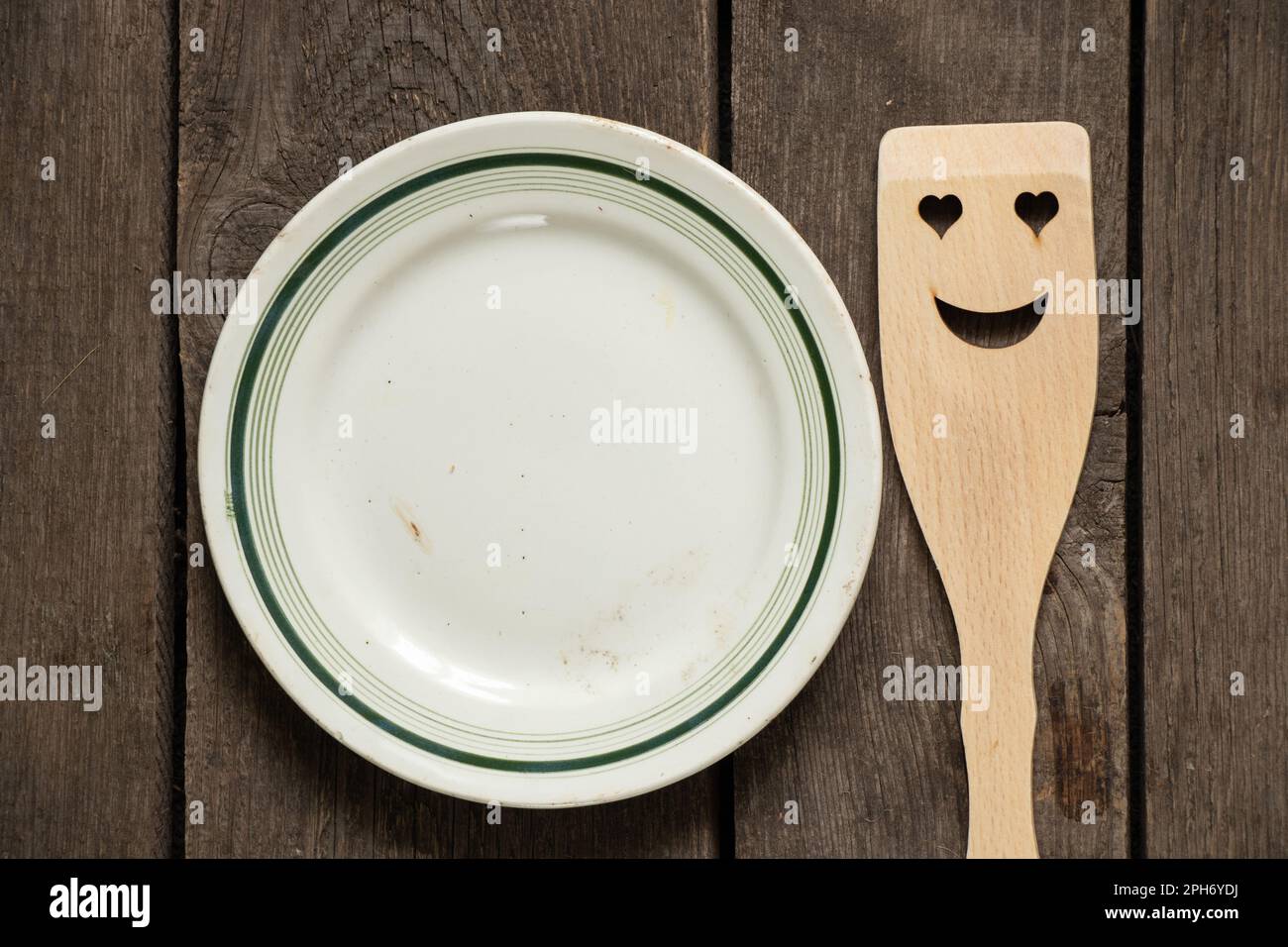 vieille vaisselle blanche en verre vide et spatule en bois avec un sourire sur une table en bois, ustensiles de cuisine Banque D'Images