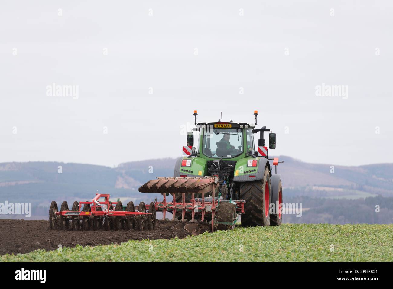 Un tracteur Fendt tractant une charrue réversible Kverneland et un labourage de double packer à Vetch, cultivé comme un fumier vert Banque D'Images