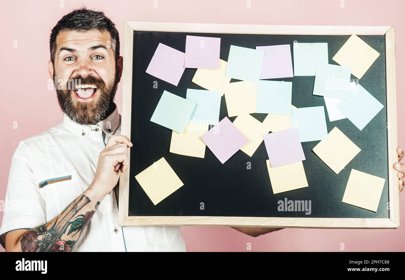 Joyeux barbu tenant une planche avec des notes collées. Concept d'affaires, de planification, de gestion et de rappel. Remarques. Créer des idées d'affaires. Homme d'affaires Banque D'Images