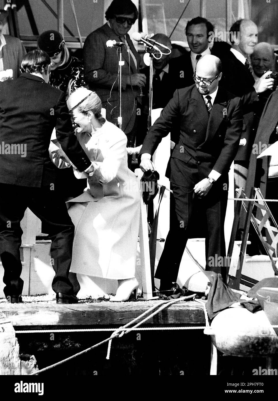 AJAXNETPHOTO. 26TH MARS 1982. COWES, ANGLETERRE. - LANCEMENT DU YACHT DE LA COUPE DE L'AMÉRIQUE - H.R.H. LA PRINCESSE MICHAEL DE KENT A ÉTÉ AIDÉE GRACIEUSEMENT À TERRE ET DANS SES CHAUSSURES APRÈS UNE VISITE PIEDS NUS DU YACHT QU'ELLE VENAIT DE NOMMER TANDIS QUE LE PROPRIÉTAIRE DE LA VICTOIRE MARCHAND BANQUIER PETER DE SAVARY (À DROITE) FUMBLES AVEC SON BROGUES. LA PRINCESSE SEMBLE TROUVER LA SITUATION DÉLICATE DE MR DE SAVARY AMUSANTE. PHOTO:JONATHAN EASTLAND/AJAX REF:222904 MX340 19 (VOIR AUSSI 222904 MX340 17 ET 18) Banque D'Images