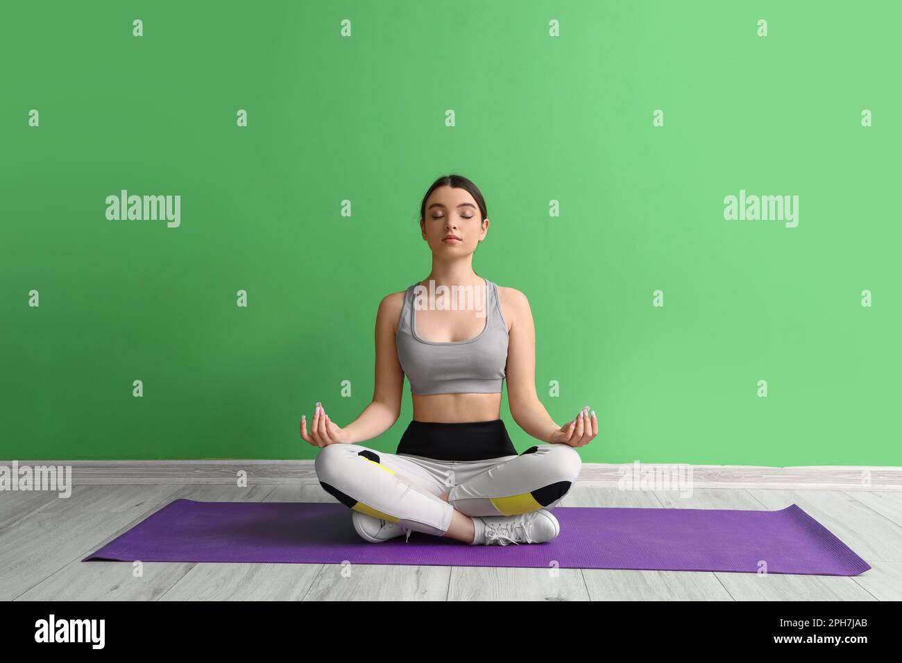 Méditer une jeune femme pratiquant le yoga en salle de gym Banque D'Images