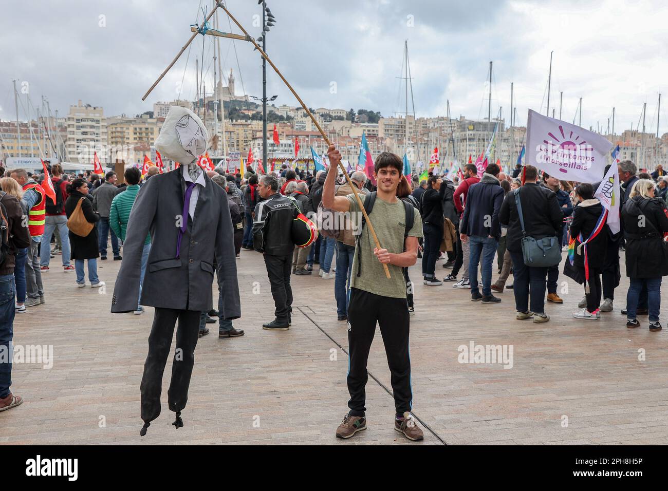 Marseille, France. 23rd mars 2023. Un jeune homme marche sur un mannequin du président français Emmanuel Macron, accroché aux jalks pendant la manifestation. Les syndicats français ont appelé à une action de 9th jours contre la réforme des retraites du gouvernement français, qui ferait passer l'âge de la retraite de 62 à 64 ans. La police a estimé, pour ce 9th jour, le nombre de manifestants qui défilaient dans les rues de Marseille à 16 000 tandis que les syndicats l'ont estimé à 280 000. (Photo de Denis Taust/SOPA Images/Sipa USA) crédit: SIPA USA/Alay Live News Banque D'Images