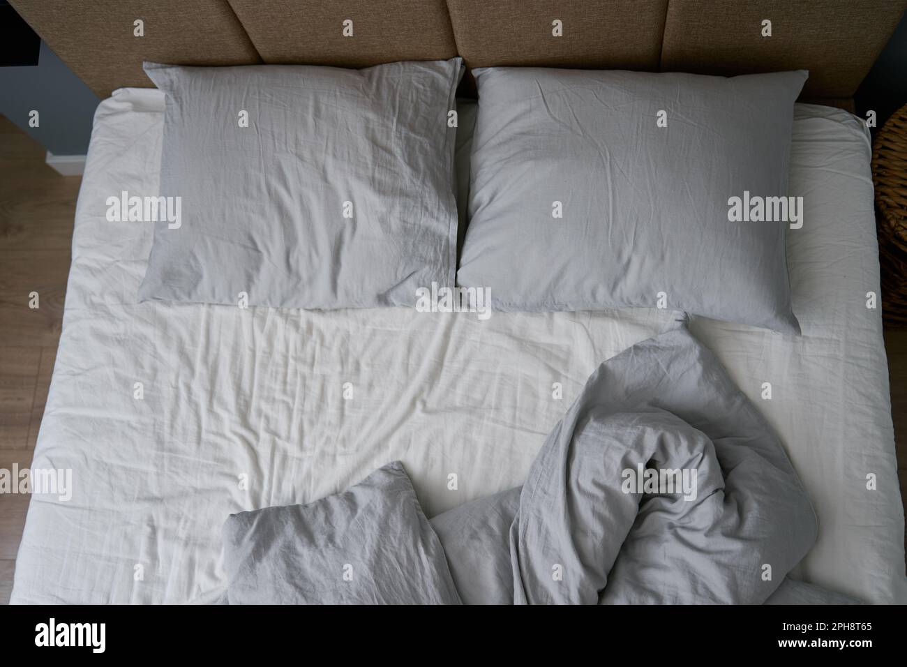 Lit non fait après avoir dormi. Lit froissé avec oreillers, couverture et draps froissés dans la chambre. Entretien ménager le matin Banque D'Images