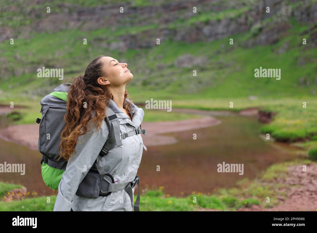 Profil d'un randonneur respirant de l'air frais au bord d'une rivière Banque D'Images