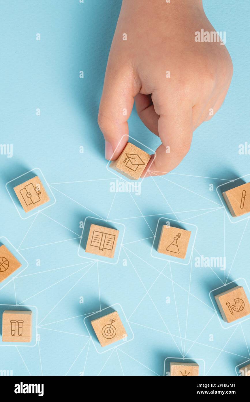 Étudiant organisant des cubes en bois avec des icônes d'éducation. Concept d'éducation Banque D'Images