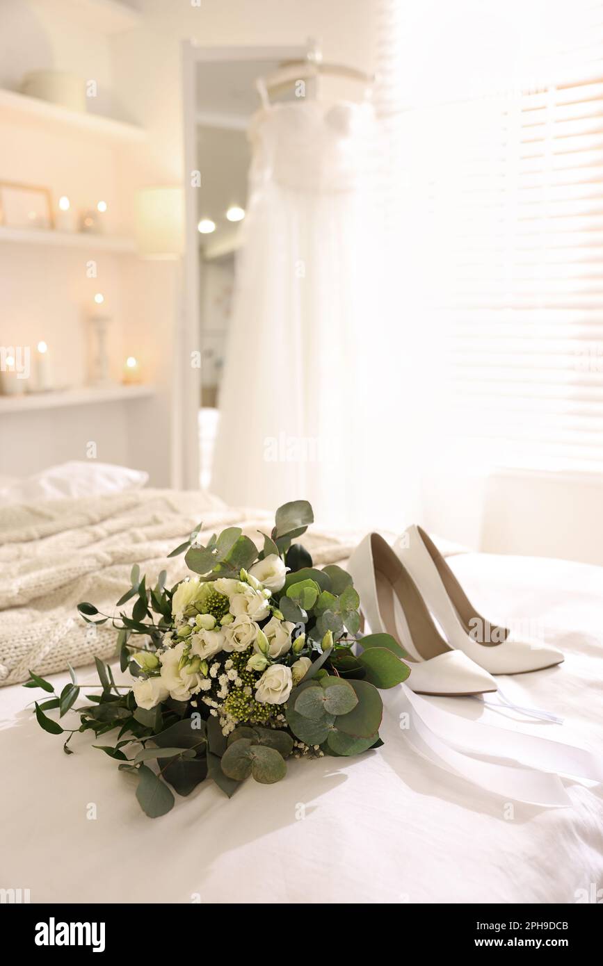 Beau bouquet de mariage et chaussures de mariée sur le lit dans la chambre Banque D'Images