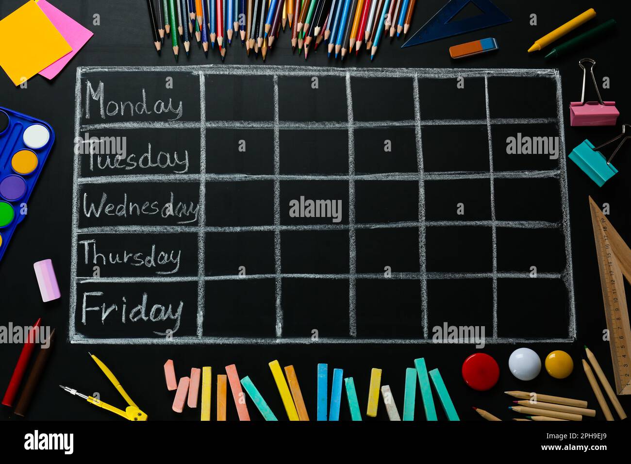 Beaucoup de différents papeterie et dessiné horaire hebdomadaire de l'école sur tableau noir, plat Banque D'Images