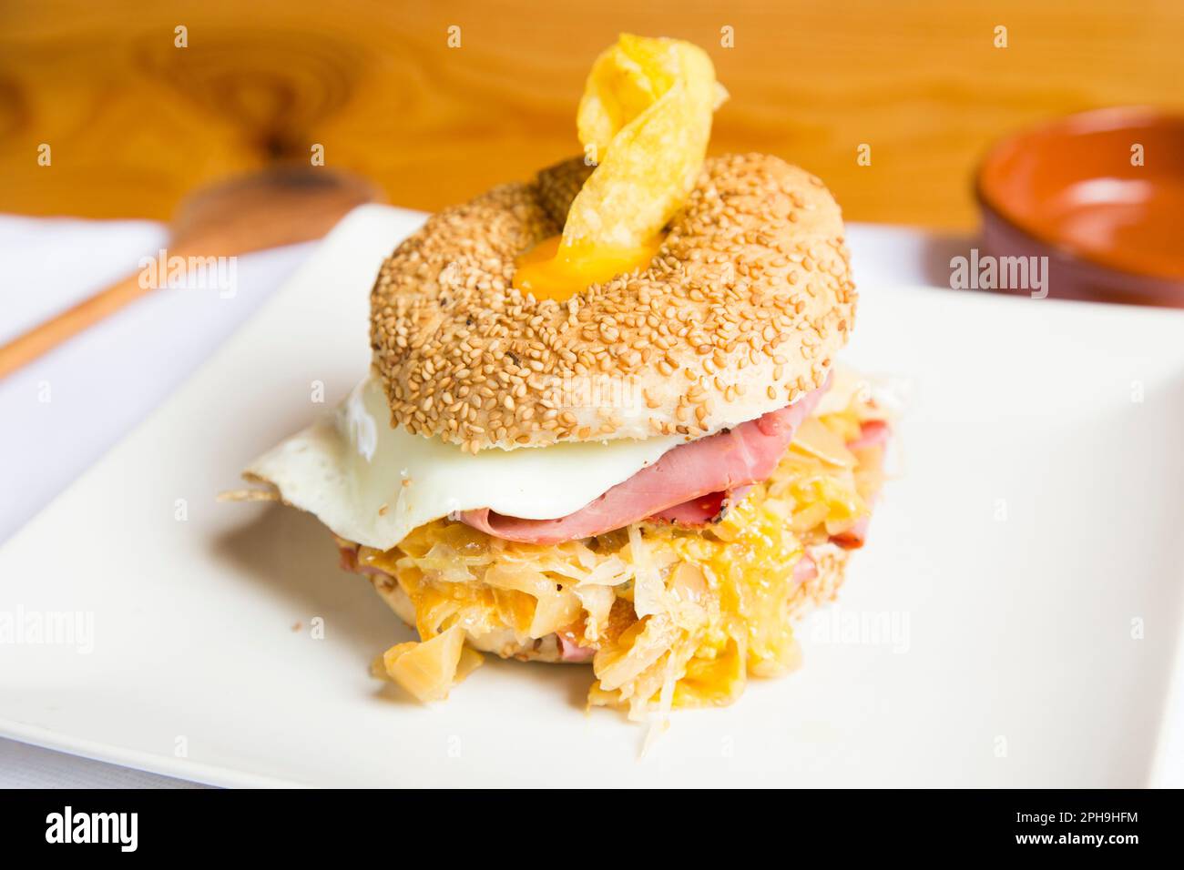 Délicieux sandwich au jambon et aux œufs sur du pain de bagel. Un bagel est un pain traditionnellement fait de farine de blé et a habituellement un trou au centre. Banque D'Images