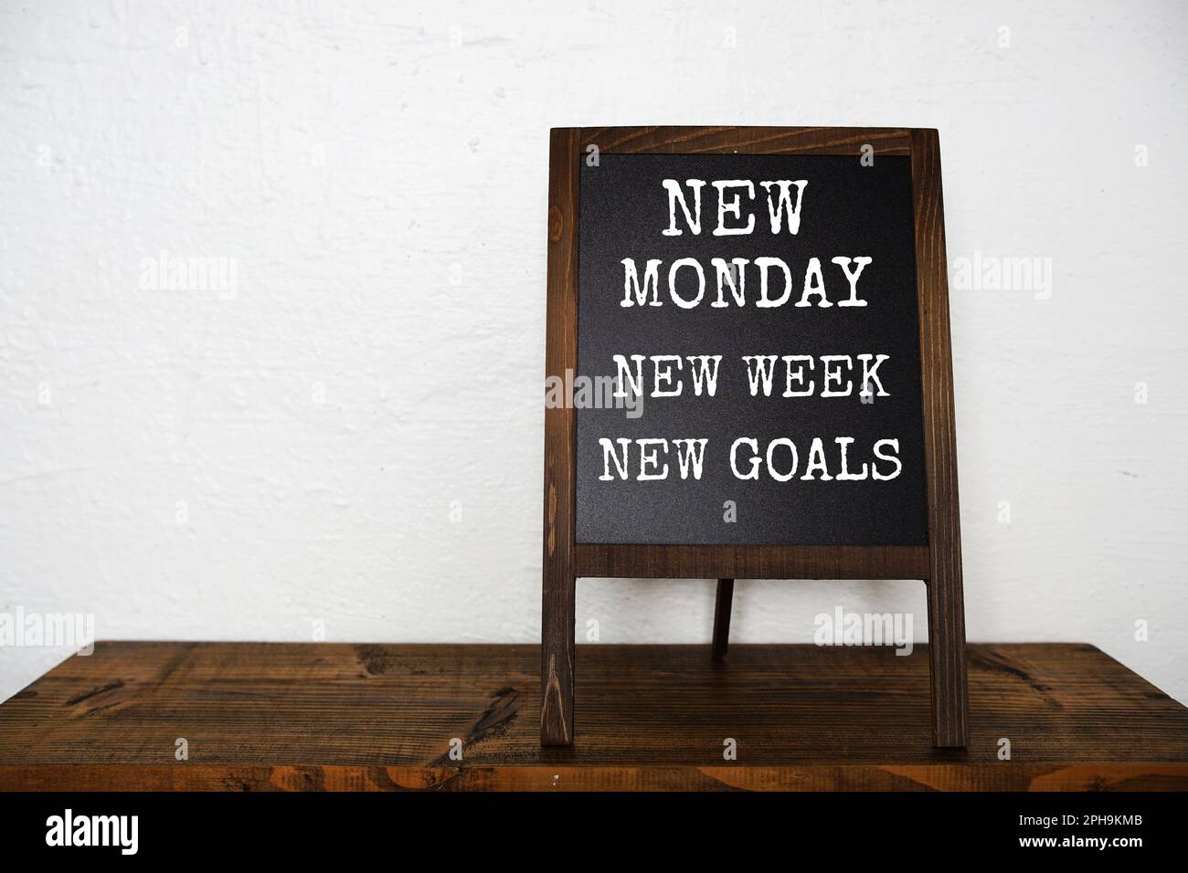 Nouveau lundi Nouvelle semaine Nouveau message de texte de but sur tableau  noir chevalet debout sur des étagères en bois Photo Stock - Alamy