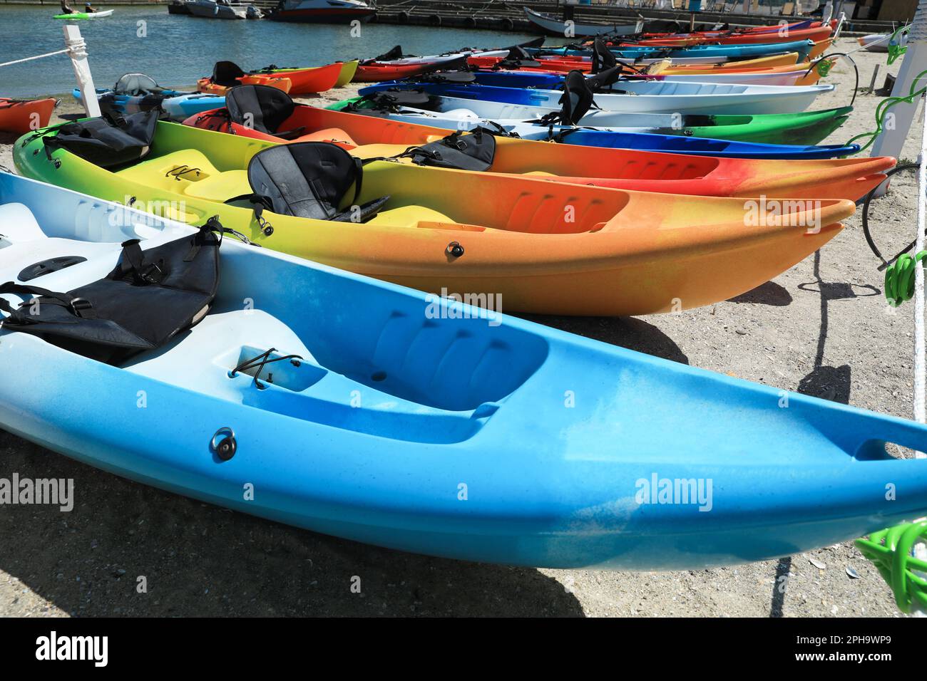 Beaucoup de kayaks colorés sur le sable près de la mer Banque D'Images Beaucoup de kayaks colorés sur le sable près de la mer Banque D'Images