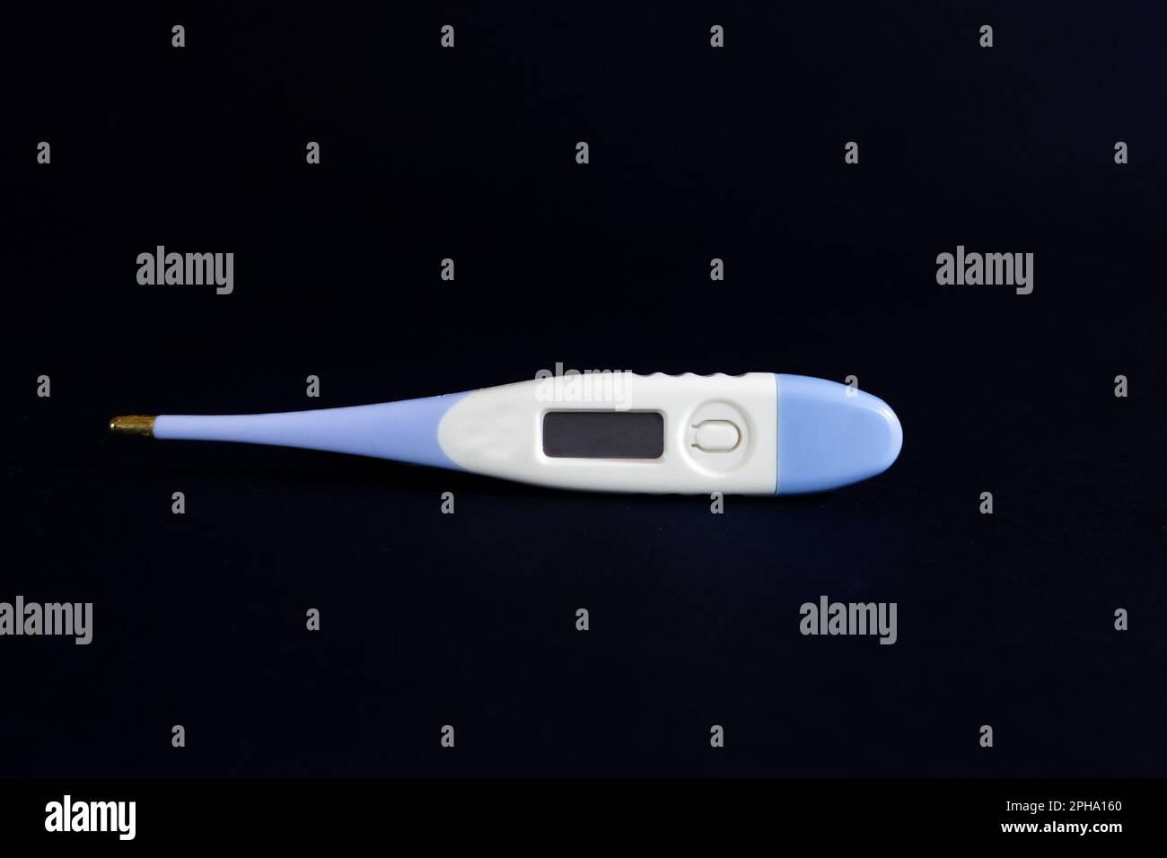 Image d'un thermomètre médical numérique blanc et bleu sur fond noir. Cet équipement médical est utilisé pour mesurer la température du corps humain. Banque D'Images