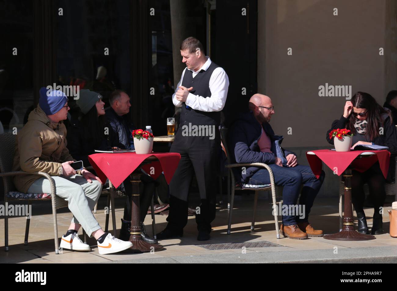 Cracovie. Cracovie. Pologne. Place du marché principal, touristes de printemps dans un café jardin d'été. Serveur prenant une commande. Banque D'Images