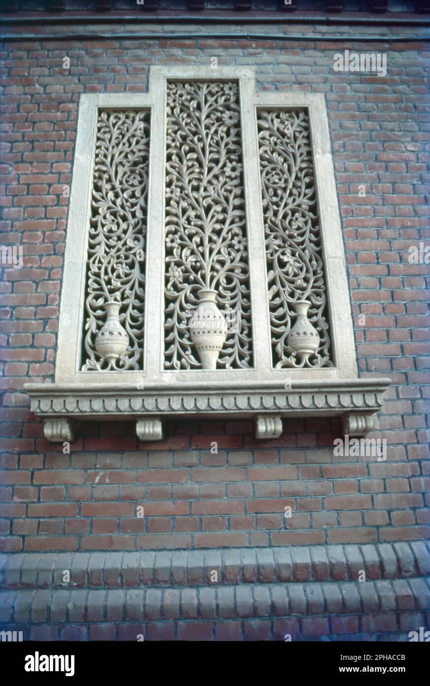 Fenêtre avec Jali articulé de fleurs et pot à Baroda, Gujrat, Inde. Banque D'Images