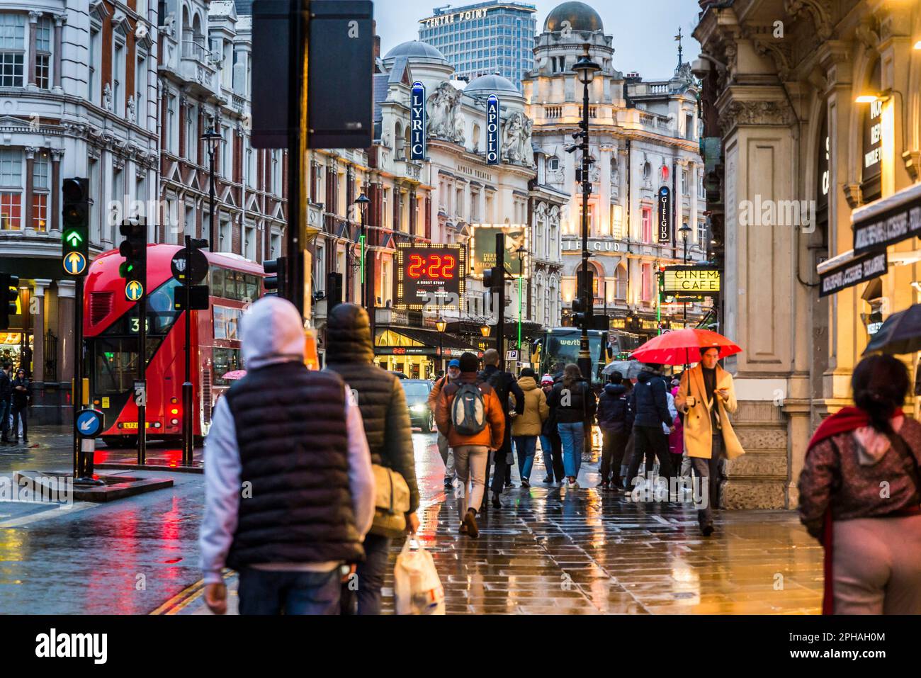 Personnes marchant sous la pluie dans Shaftesbury Avenue, une rue célèbre dans le West End Theatre Land, Londres, Angleterre, Royaume-Uni Banque D'Images