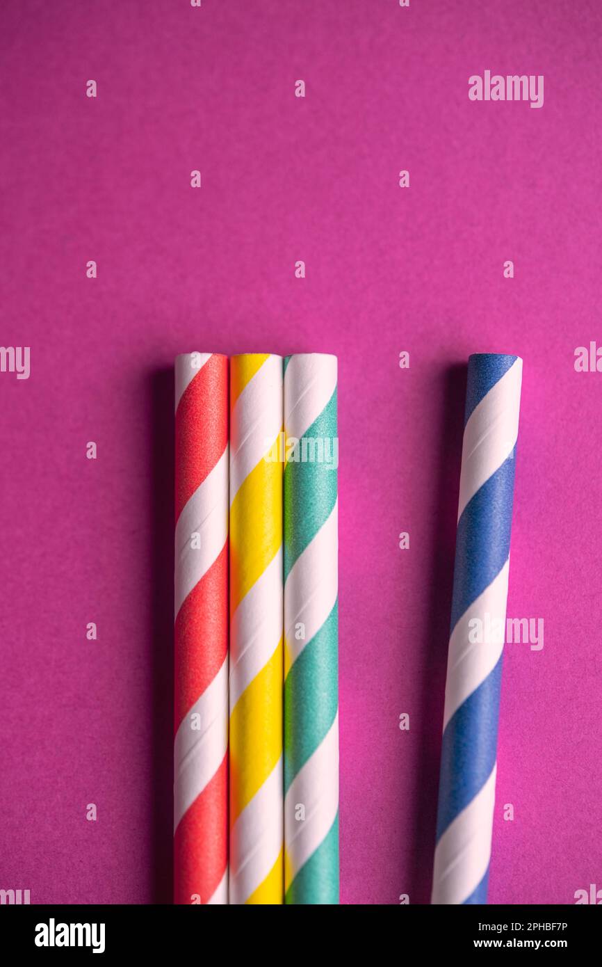 Détail de quatre pailles en papier colorées sur fond violet Banque D'Images