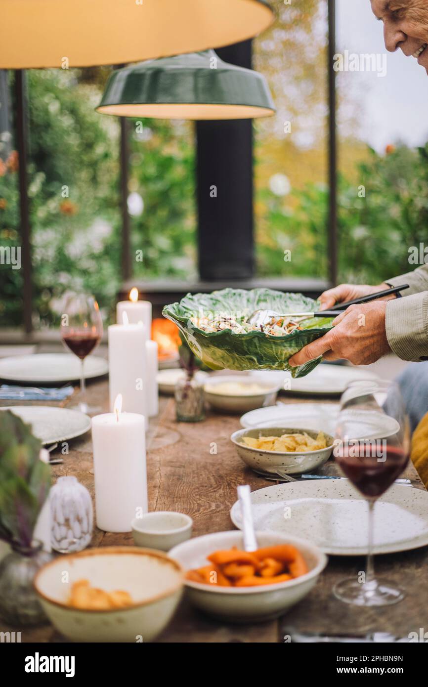 Homme senior qui fixe une table pour le dîner Banque D'Images