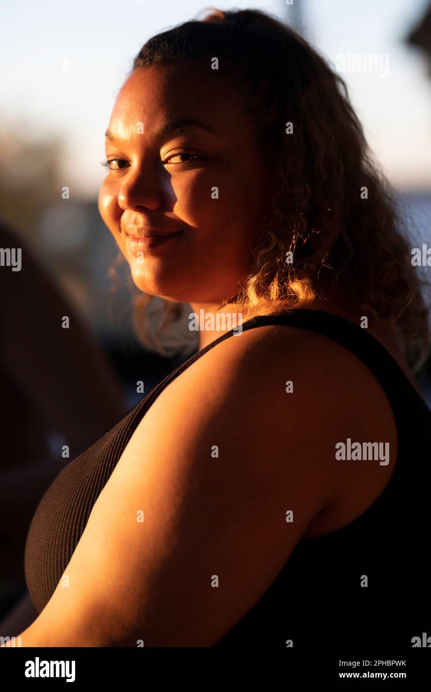 Portrait d'une femme voluptueuse souriante en vue latérale Banque D'Images