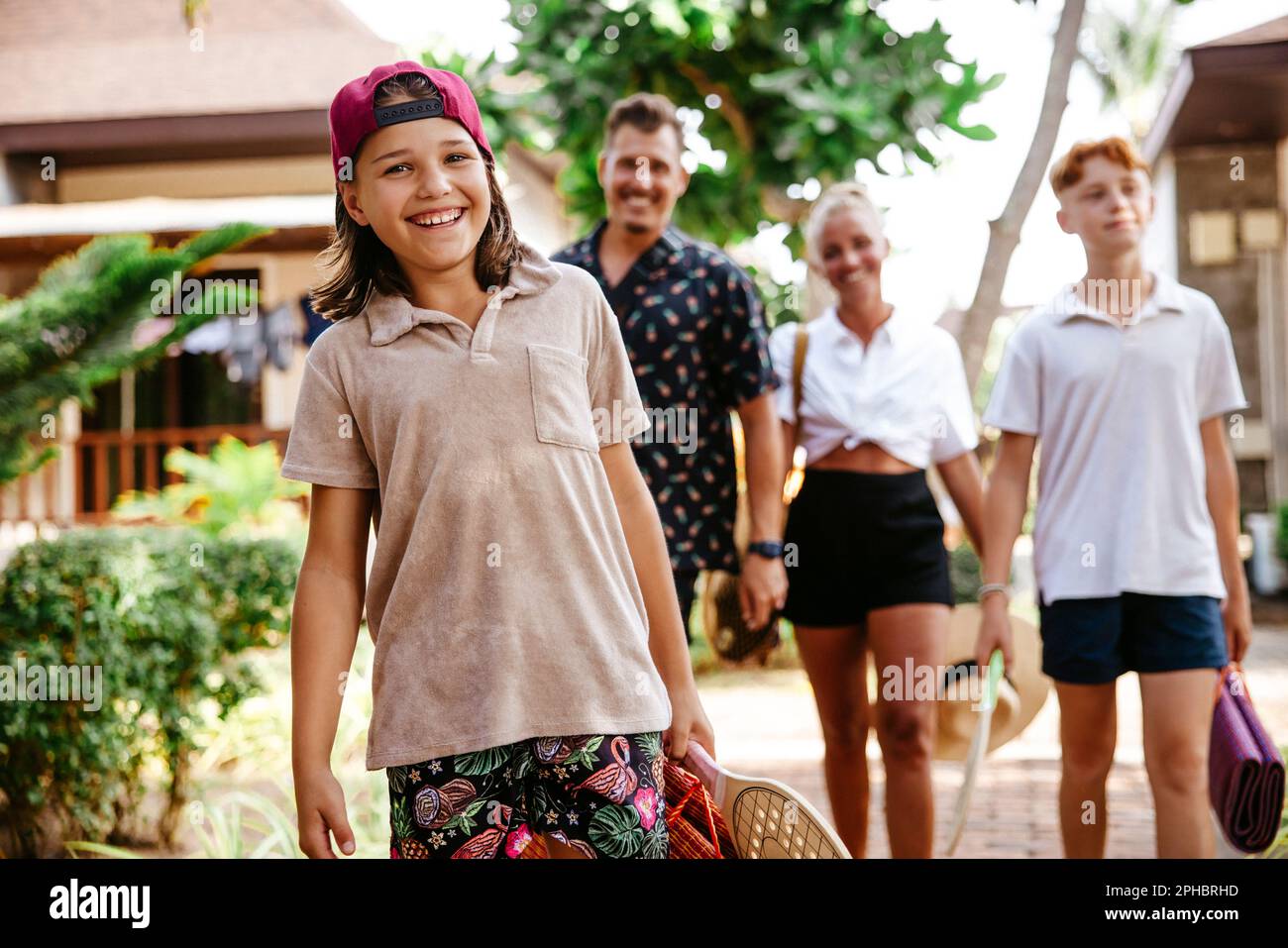 Portrait d'une fille souriante avec une famille debout en arrière-plan à la station touristique Banque D'Images
