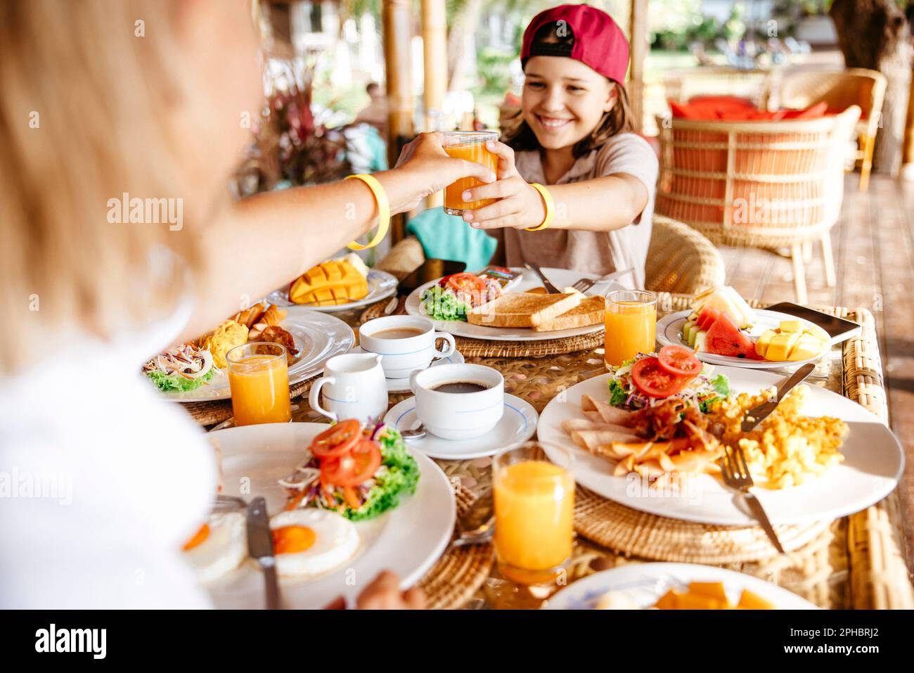 Image rognée d'une femme donnant un verre de jus à sa fille dans le Resort pendant les vacances Banque D'Images