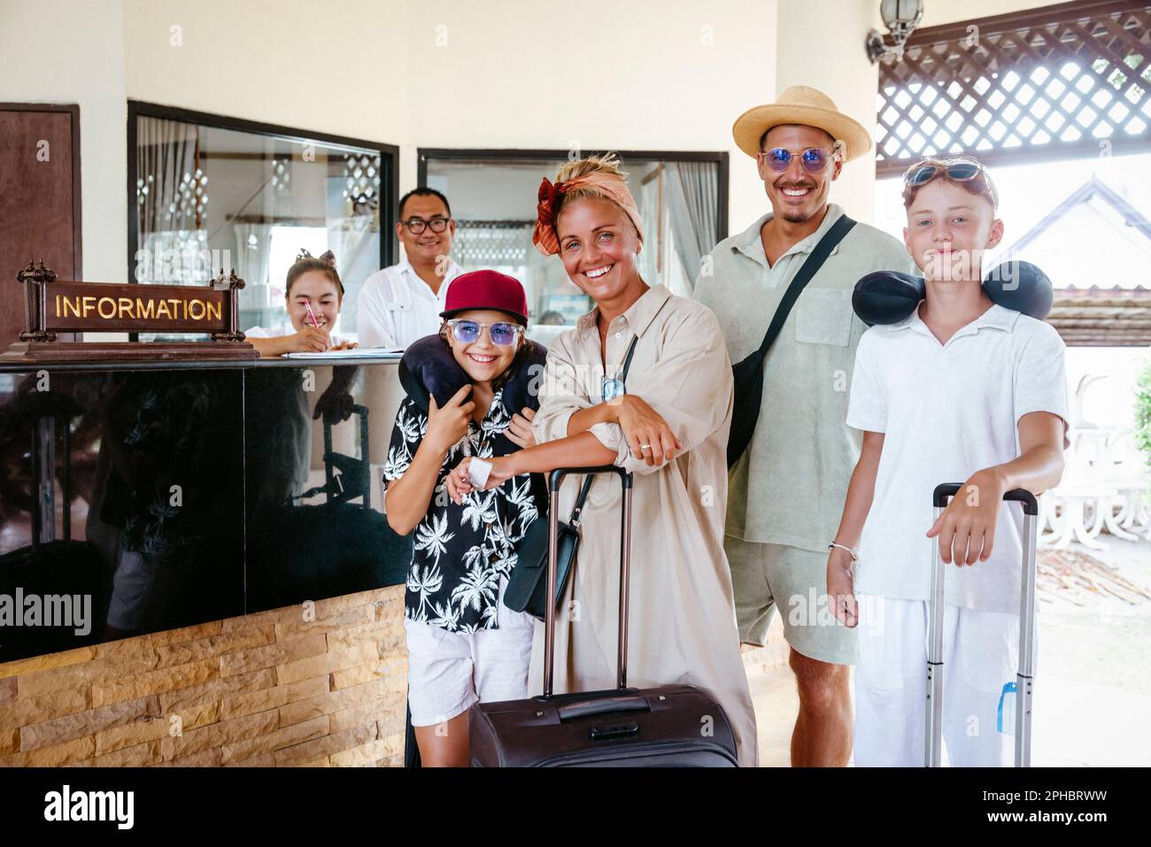 Portrait de famille heureuse avec réceptionnistes debout dans la station touristique Banque D'Images