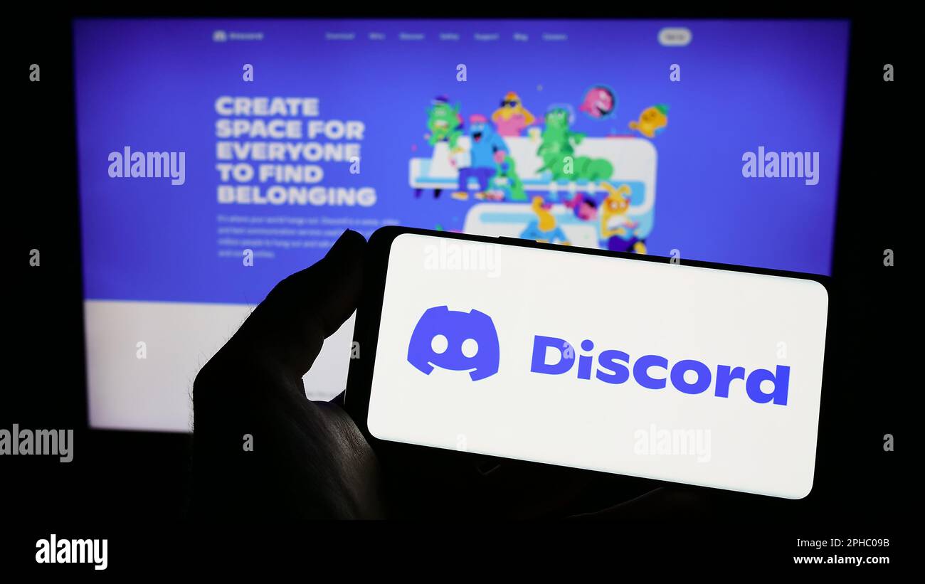 Personne tenant un smartphone avec le logo de la société de réseau social américaine Discord Inc. Sur l'écran devant le site Web. Mise au point sur l'affichage du téléphone. Banque D'Images